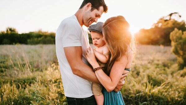 Young couple embrace baby after learning about HSA insurance plans through HSA for America